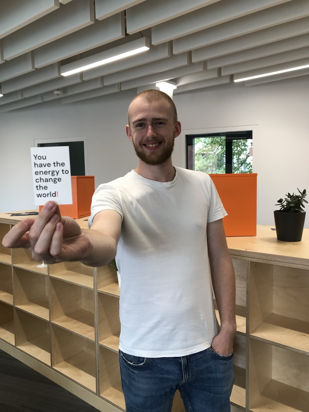 Nik holding a Felloz card that says: You have the energy to change the world!