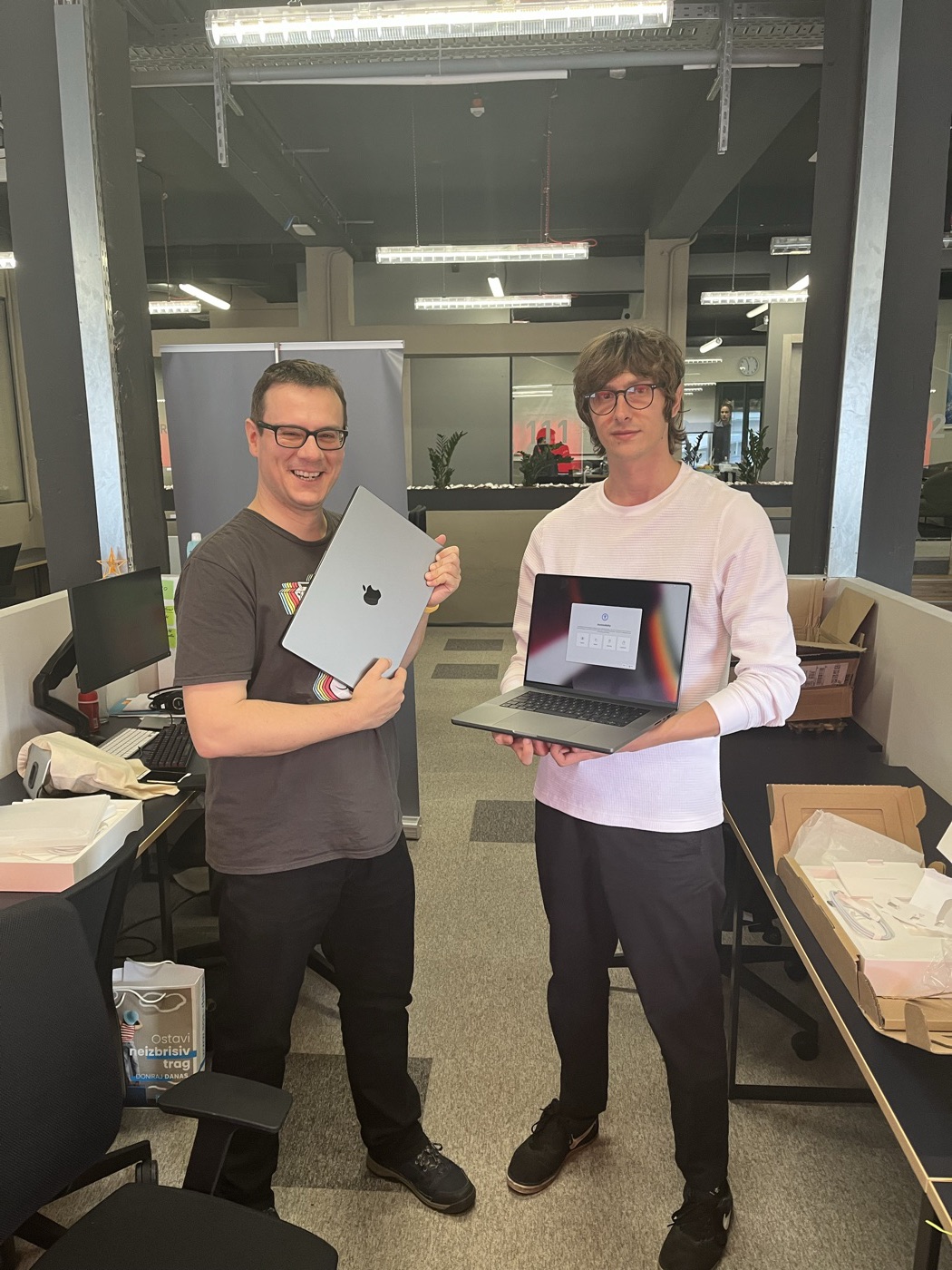 Two Felloz developers holding their new MacBooks