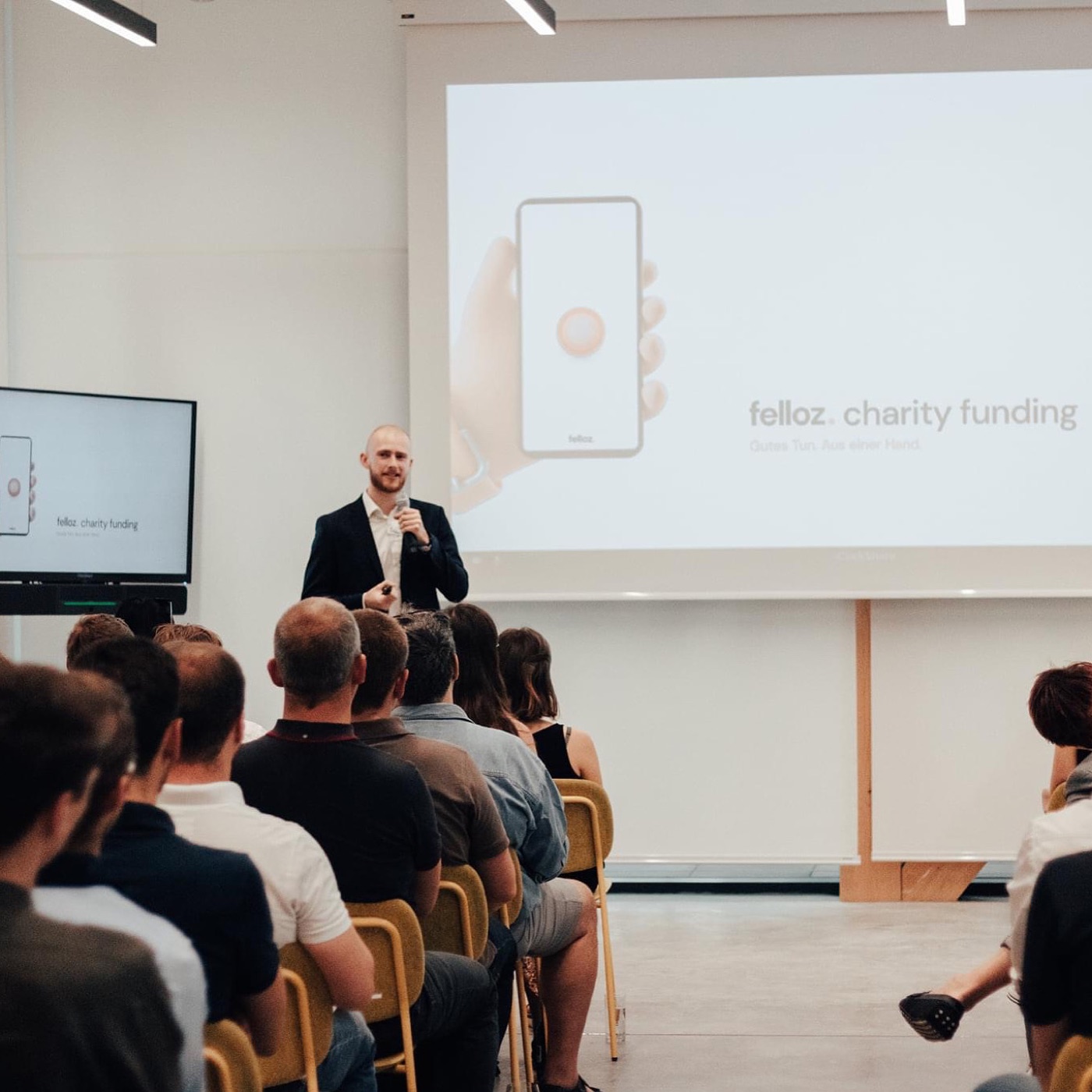 Nik pitching Felloz on stage in front of an audience